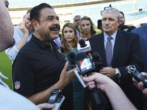 Jacksonville Jaguars owner Shad Khan, left, fields questions from the media on his interest in buying Wembley Stadium in London ahead of the Uniform Launch and Draft Party NFL football event at EverBank Field in Jacksonville, Fla., Thursday, April 26, 2018. The English Football Association has received an offer from Khan of about 600 million pounds ($840 million) for the national soccer stadium, which would continue to host England games and major cup finals after a sale.