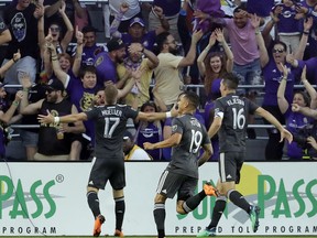 Orlando City's Chris Mueller (17) celebrates his goal with Yoshimar Yotun (19) and Sacha Kljestan (16) in front of fans, during the first half of an MLS soccer match against the San Jose Earthquakes on Saturday, April 21, 2018, in Orlando, Fla.