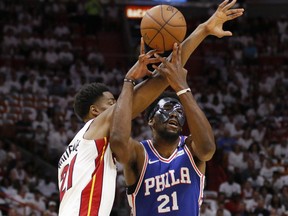 Philadelphia 76ers center Joel Embiid (21) and Miami Heat center Hassan Whiteside (21) battle for a loose ball in the first quarter in Game 4 of a first-round NBA basketball playoff series, Saturday, April 21, 2018, in Miami.