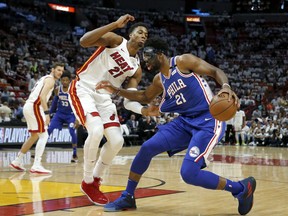 Philadelphia 76ers center Joel Embiid (21) drives as Miami Heat center Hassan Whiteside (21) defends in the first quarter in Game 4 of a first-round NBA basketball playoff series, Saturday, April 21, 2018, in Miami.