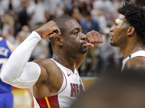 Miami Heat guard Dwyane Wade, left, reacts after his score late in the fourth quarter against the Philadelphia 76ers in Game 4 of a first-round NBA basketball playoff series, Saturday, April 21, 2018, in Miami. Heat forward Justise Winslow, right, looks on.