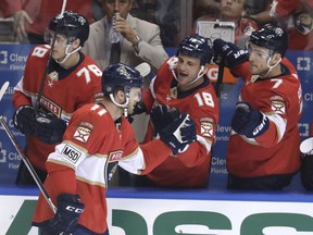 Florida Panthers' Jonathan Huberdeau, left, celebrates with Micheal Haley (18) and Colton Sceviour (7) after scoring a goal during the first period of an NHL hockey game against the Buffalo Sabres, Saturday, April 7, 2018, in Sunrise, Fla.