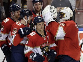 Florida Panthers goaltender Roberto Luongo, right, is congratulated by teammates after they defeated the Boston Bruins in an NHL hockey game, Thursday, April 5, 2018, in Sunrise, Fla. It was Luongo's 1,000th career NHL game.