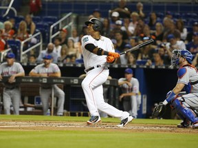 Miami Marlins' Starlin Castro hits a single during the first inning of a baseball game against the New York Mets, Tuesday, April 10, 2018, in Miami.