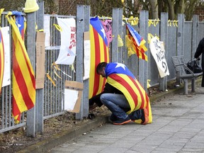 A man attaches a Catalan flag to the fence of the prison in Neumuenster, northern Germany, Wednesday, April 4, 2018 where former Catalan leader Carles Puigdemont is detained.