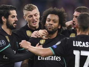 Madrid's Marcelo, center,  is congratulated by his teammates after scoring his side's first goal during the soccer Champions League first leg semifinal soccer match between FC Bayern Munich and Real Madrid in Munich, southern Germany, Wednesday, April 25, 2018.