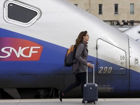 A woman walks past high-speed trains at the Saint Charles station in Marseille, southern France, Tuesday April 3, 2018.