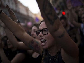 A woman shouts slogans with others during a protest outside the Justice Ministry in Madrid, Thursday, April 26, 2018. Women's rights groups protested Thursday after a court in northern Spain sentenced five men to nine years each in prison for the lesser crime of sexual abuse in what activists saw as a gang rape during the 2016 running of the bulls festival in Pamplona.