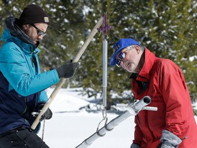 File - In this March 5, 2018, file photo, Frank Gehrke, chief of the California Cooperative Snow Surveys Program for the Department of Water Resources, right, reads the weight of the snow sample, on a scale held by Dylan Chapple, a fellow with the California Council of Science and Technology, during a supplemental snow survey near Echo Summit, Calif. Californians close out their rainy season with the break they were hoping for, as a series of late-winter storms ease drought conditions that had been setting in again.
