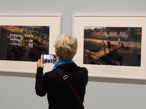 In this March 15, 2018 photo, a woman views a pair of Paul Fusco photographs that are part of the exhibit, "The Train: RFK's Last Journey," at the San Francisco Museum of Modern Art in San Francisco.