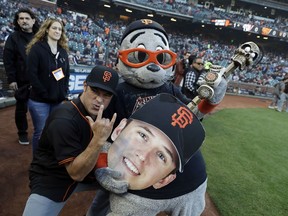 Metallica's Robert Trujillo poses for pictures with San Francisco Giants mascot Lou Seal during before a baseball game against the Washington Nationals Monday, April 23, 2018, in San Francisco.