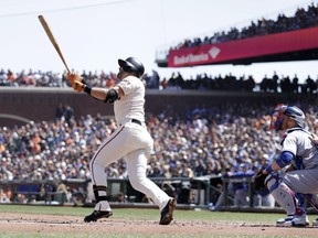 San Francisco Giants' Evan Longoria, center, follows through on his three-run home run against the Los Angeles Dodgers during the first inning of a baseball game Sunday, April 29, 2018, in San Francisco.