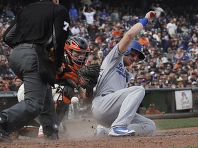 Los Angeles Dodgers' Cody Bellinger, right, scores next to San Francisco Giants catcher Nick Hundley during the eighth inning of a baseball game in San Francisco, Saturday, April 28, 2018.