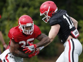 Georgia running back Brian Herrien (35) takes a hand off from quarterback Jake Fromm during spring NCAA college football practice, Thursday, April 5, 2018, in Athens, Ga.