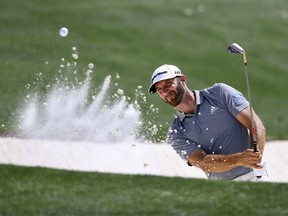 Dustin Johnson blasts from a bunker to the 18th green during a practice round for the Masters golf tournament at Augusta National Golf Club in Augusta, Ga., Tuesday, April 3, 2018.