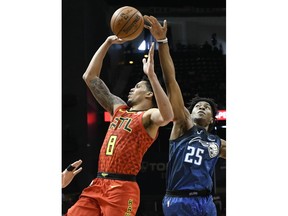 Atlanta Hawks guard Damion Lee shoots as Orlando Magic forward Wesley Iwundu (25) tries to get a hand on the ball during the first half of an NBA basketball game Sunday, April 1, 2018, in Atlanta.