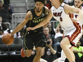 Atlanta Hawks guard Tyler Dorsey tries to get past Miami Heat forward Kelly Olynyk (9) during the first half of an NBA basketball game Wednesday, April 4, 2018, in Atlanta.