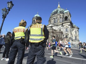 Police observe the half marathon in front of the Berlin Cathedral, in Berlin, Sunday, April 8, 2018.