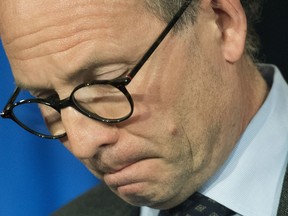 Quebec Public Safety Minister Martin Coiteux drops his head during a news conference in Montreal Friday, April 27, 2018, where he announced he would be retiring from politics.