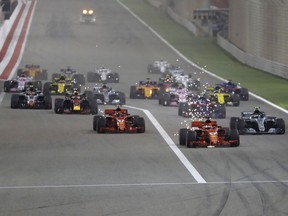 Sparks fly off the car of Ferrari driver Sebastian Vettel of Germany, center as he leads at the start of the Bahrain International Circuit in Sakhir, Bahrain, Sunday, April 8, 2018.
