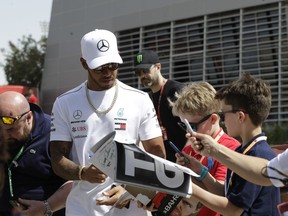 Mercedes driver Lewis Hamilton, right, of Britain meets fans as he arrives at the track ahead of the third free practice at the Formula One Bahrain International Circuit in Sakhir, Bahrain, Saturday, April 7, 2018. The Bahrain Formula One Grand Prix will take place here on Sunday.