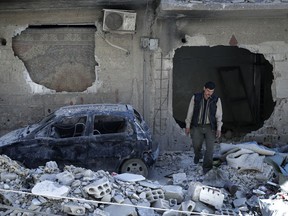 In this Monday, April 16, 2018 photo, man walks just metres away from where the alleged chemical weapons attack occurred in the town of Douma, the site of a suspected chemical weapons attack, near Damascus, Syria.