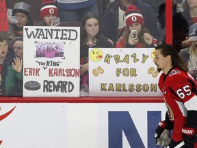 Fans hold up signs in support of Ottawa Senators captain Erik Karlsson during warm-up before a home game against the Winnipeg Jets on April 2.