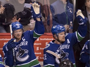 Vancouver Canucks forwards Henrik (left) and Daniel Sedin wave to the crowd during a standing ovation against the Vegas Golden Knights on April 3.
