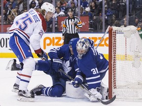 Maple Leafs goaltender Frederik Andersen makes a stop as defenceman Ron Hainsey falls into him and the Montreal Canadiens' Jacob de la Rose looks on during first period action in Toronto on Saturday night.