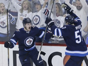 Andrew Copp celebrates his goal with Jets teammate Tyler Myers against the Minnesota Wild during third-period action in Game 2 of their Western Conference playoff series on Friday night in Winnipeg.