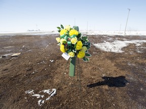 Members of the RCMP lay flowers at the intersection of a crash site near Tisdale, Sask., Sunday, April, 8, 2018.