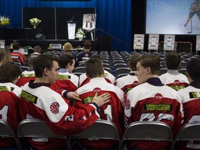 A funeral attendant puts a Thomas sticker on the the back of another person's jersey before the funeral for Humboldt Broncos player Evan Thomas in Saskatoon, Sask., on Monday, April, 16, 2018.