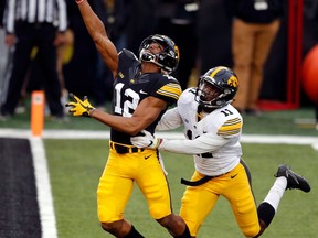 Iowa wide receiver Brandon Smith (12) tries to make a reception over defensive back Michael Ojemudia (11) during the team's NCAA college football spring scrimmage Friday, April 20, 2018, in Iowa City, Iowa. The pass was incomplete.