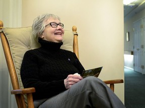 In this March 29, 2018 photo, Sharon Gongwer smiles in Goshen, Ind., as she receives a postcard from her mother written 60 years ago, delivered by Quality Inn & Suites manager Christine Combs, who found the postcard in a file cabinet at the hotel.