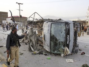 A Pakistani police officer walks past a police vehicle targeted by a suicide bomber in Quetta, Pakistan, Tuesday, April 24, 2018. Pakistan's military says suicide bombers blew themselves up near a police vehicle and a security checkpoint in separate incidents in the southwestern city of Quetta, killing many police officers and wounding eight paramilitary troops.