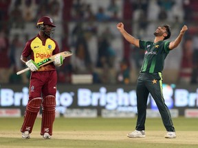 FILE - In this Monday, April 2, 2018 file photo, Pakistani bowler Mohammad Amir, right, celebrates the dismissal of West Indies captain Jason Mohammed in Karachi, Pakistan. Amir's departure for the tours of Ireland and England has been delayed due to delay in obtaining his visa. "Amir could not travel with the team," the Pakistan Cricket Board spokesman Amjad Bhatti confirmed to the AP.
