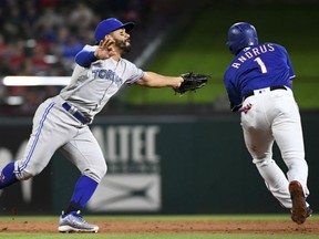 Devon Travis, left, of the Toronto Blue Jays, extends to no avail as he misses the tag on Texas Rangers' base runner Elvis Andrus during MLB action in Arlington, Texas on Friday. The Jays were 8-5 winners.
