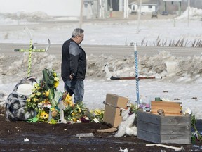 Myles Shumlanski looks around a makeshift memorial at the intersection of a fatal bus crash near Tisdale, Sask., Tuesday, April, 10, 2018. Shumlanski's son Nick was one of the survivors of a fatal bus crash. Nick was on a bus carrying the Humboldt Broncos hockey team when crashed into a truck en route to Nipawin for a game Friday night killing 15 and sending over a dozen more to the hospital.