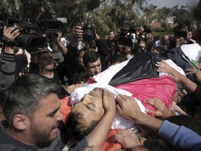 Mourners carry the body of Palestinian cameraman who was shot and killed, Friday by Israeli troops while covering a protest at the Gaza Strip's border with Israel, during his funeral in Gaza City, Saturday, April 7, 2018.