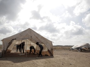 Palestinian protesters set up tents at the Gaza Strip's border with Israel, Thursday, April 19, 2018. Palestinian activists are moving protest encampments closer to Israel's fence ahead of mass demonstration.