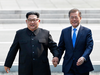 North Korean leader Kim Jong Un, left, and South Korean President Moon Jae-in hold hands as they cross the border at the border village of Panmunjom in Demilitarized Zone, April 27, 2018.