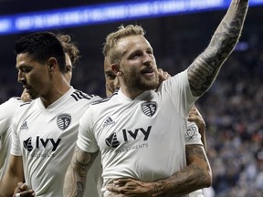 Sporting Kansas City forward Johnny Russell raises his fist in celebration of his first goal of the night during the first half of an MLS soccer match against the Vancouver Whitecaps in Kansas City, Kan., Friday, April 20, 2018.