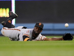 San Francisco Giants center fielder Andrew McCutchen can't get to a ball hit for a triple by Los Angeles Dodgers' Chris Taylor during the third inning of a baseball game Saturday, March 31, 2018, in Los Angeles.