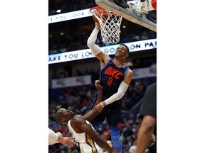 Oklahoma City Thunder guard Russell Westbrook (0) misses a dunk over New Orleans Pelicans center Emeka Okafor during the first half of an NBA basketball game in New Orleans, Sunday, April 1, 2018.