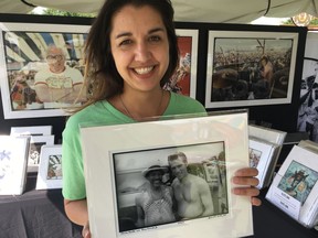 Amanda McFillen shows a picture taken at the 1989 New Orleans Jazz & Heritage Festival of saxophone player Charles Neville posing with Harry Connick Jr. The image was among those on sale Friday, April 27, 2018 at the festival by the Historic New Orleans Collection in New Orleans. Neville died Thursday, April 26, 2018.