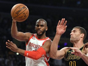 Houston Rockets guard Chris Paul, left, passes the ball as Los Angeles Lakers center Brook Lopez defends during the first half of an NBA basketball game Tuesday, April 10, 2018, in Los Angeles.