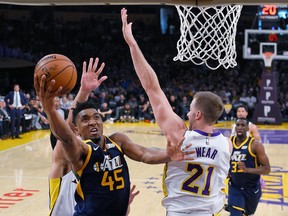 Utah Jazz guard Donovan Mitchell, left, shoots as Los Angeles Lakers forward Travis Wear defends during the first half of an NBA basketball game Sunday, April 8, 2018, in Los Angeles.