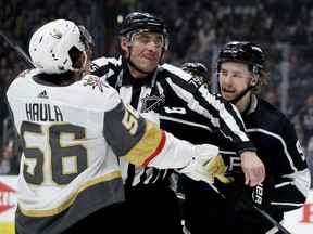 Linesman Derek Amell (75) separates Vegas Golden Knights left wing Erik Haula, left, and Los Angeles Kings left wing Adrian Kempe during the first period of Game 3 of an NHL hockey first-round playoff series in Los Angeles, Sunday, April 15, 2018.