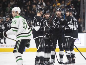 Los Angeles Kings team celebrate defenseman Alec Martinez's goal as Dallas Stars center Devin Shore skates away during the second period of an NHL hockey game Saturday, April 7, 2018, in Los Angeles.