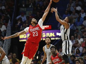 New Orleans Pelicans forward Anthony Davis (23) blocks a shot by San Antonio Spurs guard Patty Mills (8) in the first half of an NBA basketball game in New Orleans, Wednesday, April 11, 2018.